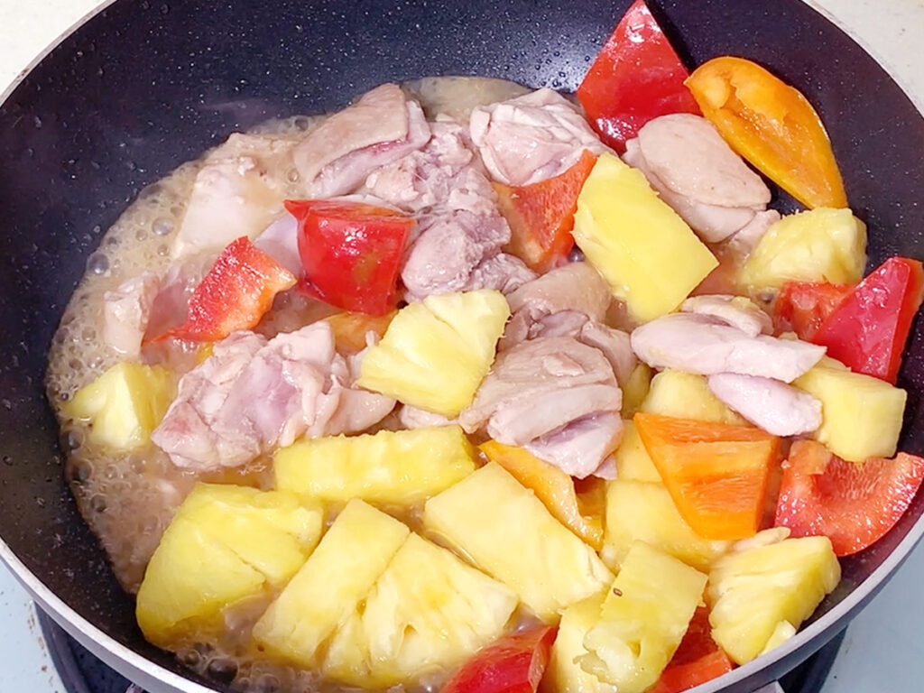 鳳梨料理食譜步驟:熱油鍋,放入雞腿肉,帶雞皮煎到金黃,再放入鳳梨、甜椒拌炒。